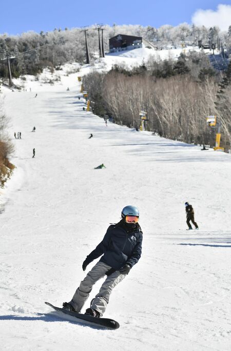 ゲレンデを滑走するスノーボーダーら