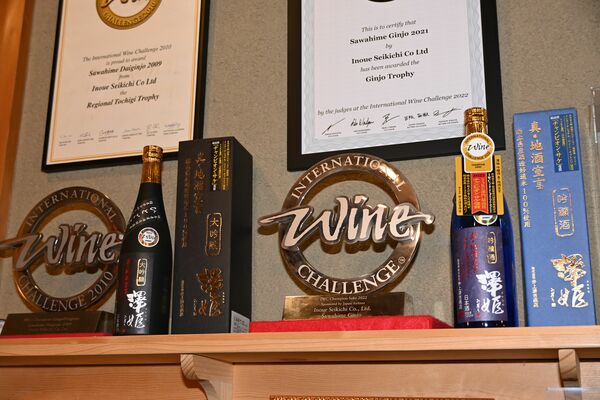 井上清吉商店の直売所に展示される２回のＩＷＡチャンピオン・サケのトロフィーと受賞酒＝宇都宮市