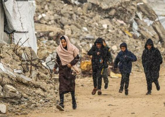 　１８日、ガザ北部ガザ市で、がれきの中を歩くパレスチナ人（ゲッティ＝共同）