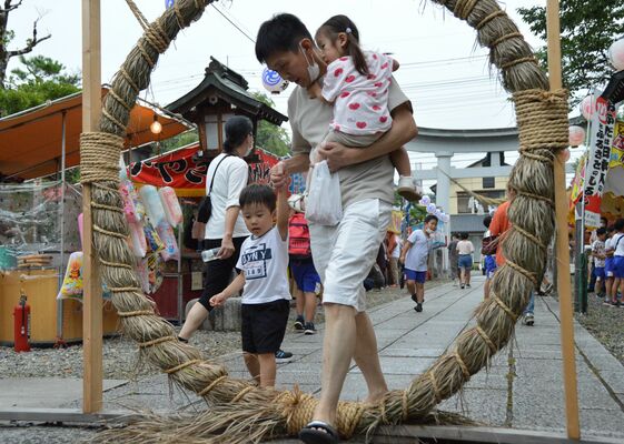 親子で茅の輪をくぐる参拝者