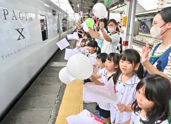 東武新鹿沼駅のホームで列車を出迎えた園児ら＝15日午前９時17分、鹿沼市