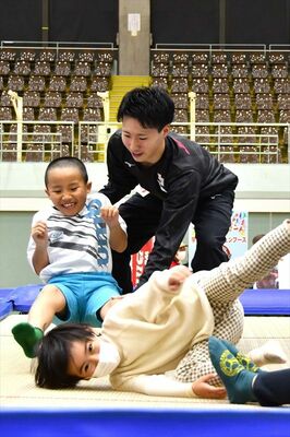 山田選手（中央）の指導の下でトランポリンを体験する子どもたち