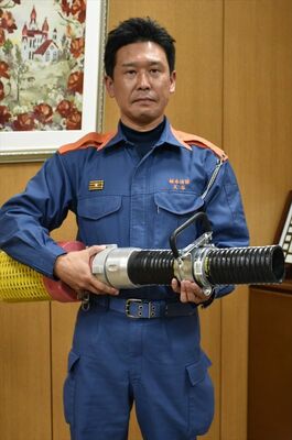 「ヨレとって」を持つ天谷さん。取っ手を持つと、黒の吸管が回ってよれが解消する