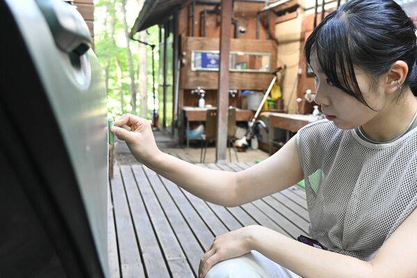 真剣な表情で野菜の絵を描く小緩さん