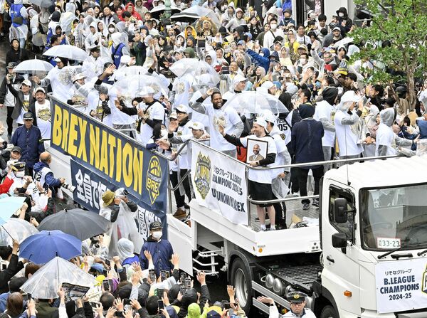 雨にもかかわらず集まった大勢のファンに、笑顔で手を振るブレックスの選手ら=31日午前10時40分、宇都宮市中央1丁目
