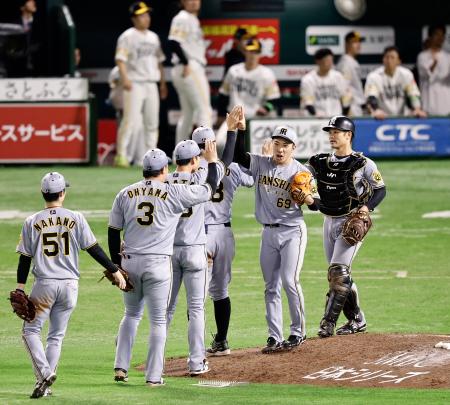ソフトバンクに逆転勝ちし、タッチする石井(右から2人目)ら阪神ナイン=みずほペイペイドーム