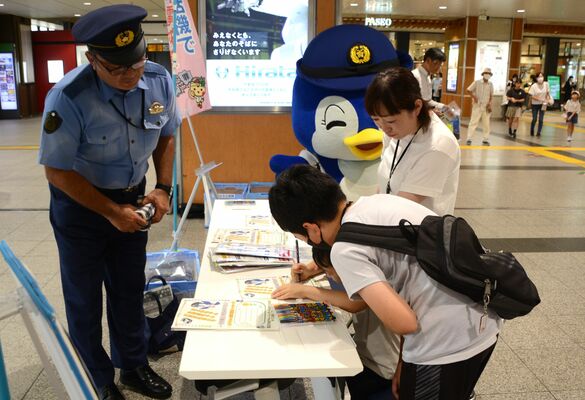 祖父母へ特殊詐欺被害防止のメッセージを書く子どもたち＝８日午前10時30分、ＪＲ宇都宮駅
