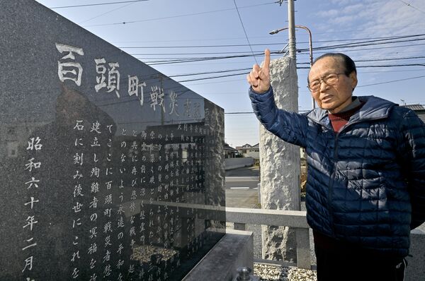 戦災者慰霊碑の前で百頭空襲の惨状を語る岡村さん=1月24日午前、足利市百頭町
