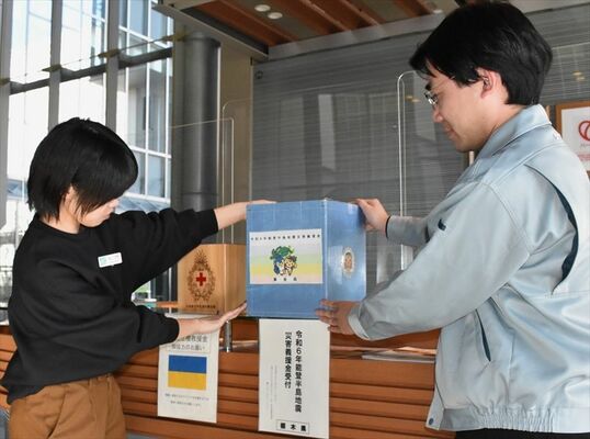被災地支援に向け、募金箱を設置する県職員＝４日午後、県庁１階ロビー