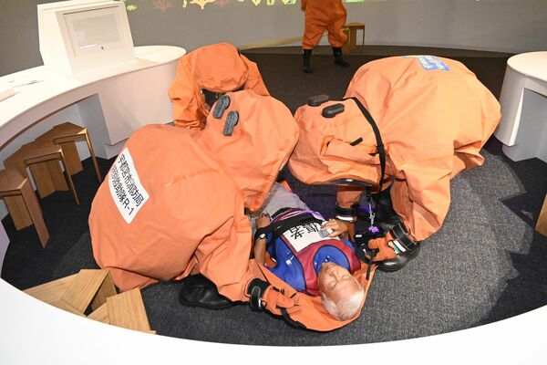 館内に取り残された傷病者役の状態を確認する宇都宮市消防局の特別高度救助隊員＝26日午前、宇都宮市西川田町