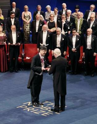 ノーベル賞授賞式で、スウェーデンのカール16世グスタフ国王(手前右)から生理学・医学賞のメダルと賞状を授与される坂口志文・大阪大特任教授(同左)=10日、ストックホルムのコンサートホール(代表撮影・共同)