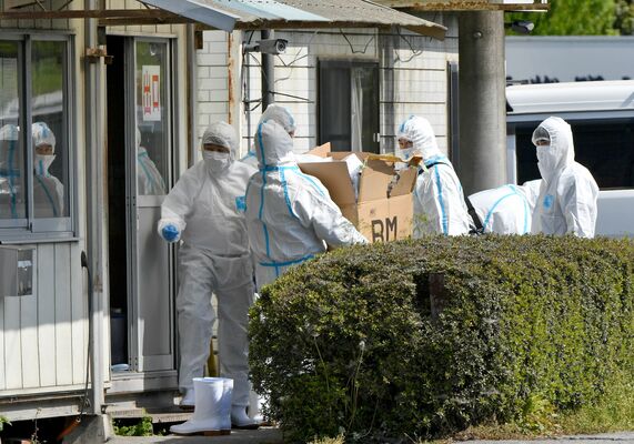 家畜伝染病対策のため防護服を着用して家宅捜索に入る県警の捜査員＝2023年４月