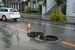 大雨の影響でマンホールがずれたままの道路＝11日午後６時55分、宇都宮市昭和１丁目
