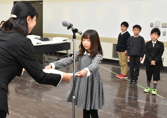 感想文コンクールで表彰状を受け取る児童たち＝23日午前、県総合文化センター