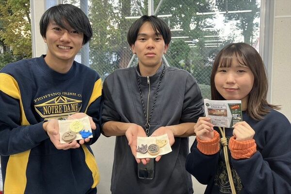 フィギュアや説明書を持つ芝浦工業大の学生