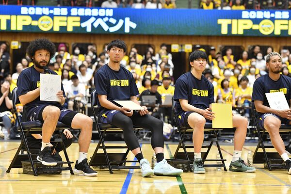 今季の目標を記した色紙を掲げながらトークするブレックスの田臥（左）ら