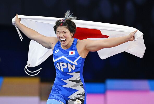パリ五輪のレスリング女子76キロ級で金メダルを獲得し、日の丸を掲げる鏡優翔＝11日、パリ（共同）