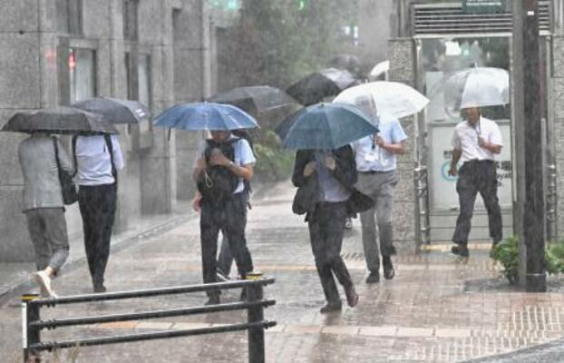 　大雨の中、傘を差して歩く人たち＝１１日午後３時３４分、東京都中央区