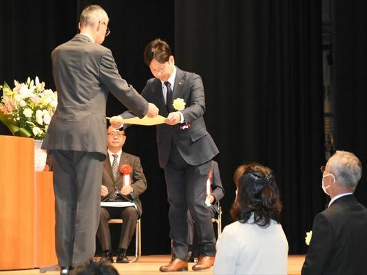 難波本部長から表彰状を受け取る代表者（中央）＝30日午後１時50分、宇都宮市文化会館
