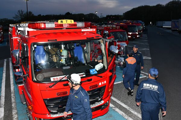 山林火災の消火支援のため、那須高原サービスエリアに集結した緊急消防援助隊の消防車両＝２４日午後６時２５分、那須町豊原丙