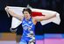 パリ五輪のレスリング女子76キロ級で金メダルを獲得し、日の丸を掲げる鏡優翔＝11日、パリ（共同）