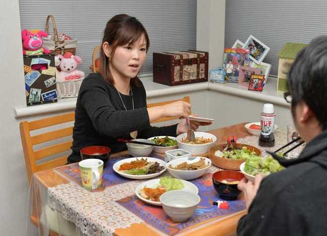 夫と食卓を囲む塩尻真由美さん。結婚当初は、普通の妻の姿が分からなかった=12月29日、宇都宮市内