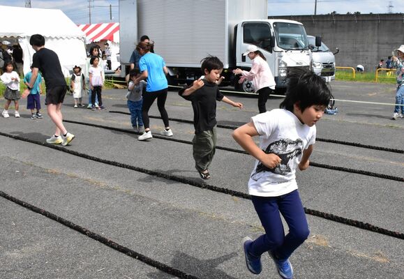 塀に囲まれた会場で催しを楽しむ子どもたち