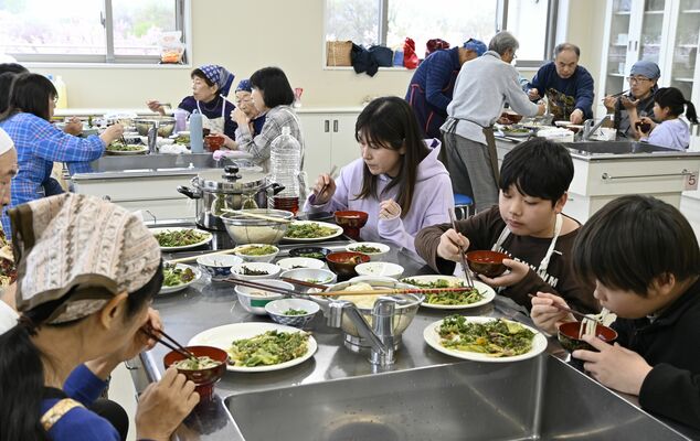 調理した野草を試食する参加者たち