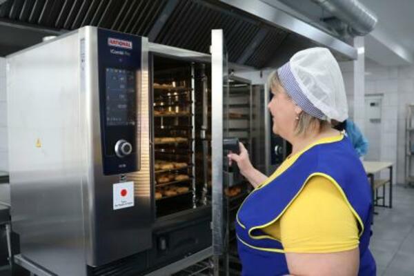 　２日、キーウの学校で、日本が供与したオーブンを使う調理担当者（共同）