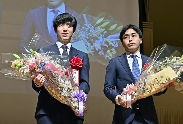 花束を手にステージに立つ藤井王将（左）と菅井八段＝６日午後６時40分、大田原市本町１丁目
