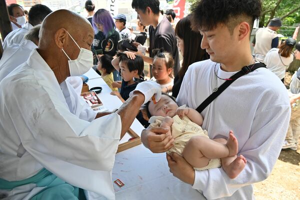 子どもの額に朱印を押してもらう参拝者