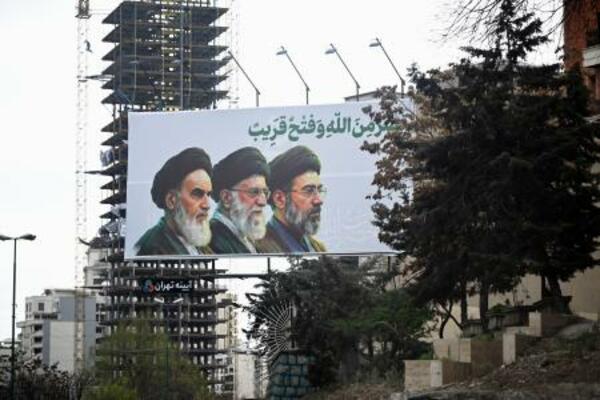 　街頭に掲げられたイランの最高指導者モジタバ・ハメネイ師（右）らの肖像＝２０日、テヘラン（共同）