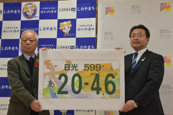 国交省に提案する日光ナンバーの図柄を手にする粉川市長（右）と見形町長