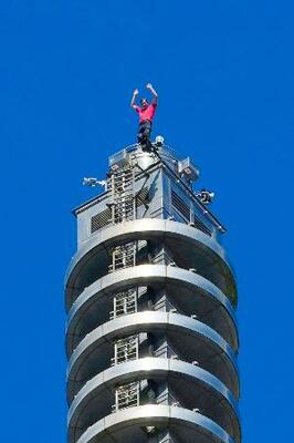 　「台北１０１」を登り切って手を振るオノルドさん＝２５日、台北（中央通信社＝共同）