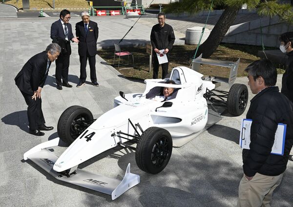 「ＭＥＦ」の説明を受ける福田知事（左上２人目）と、マシンに乗り込む松井市長ら＝９日午前11時５分、県庁昭和館、森田大地撮影