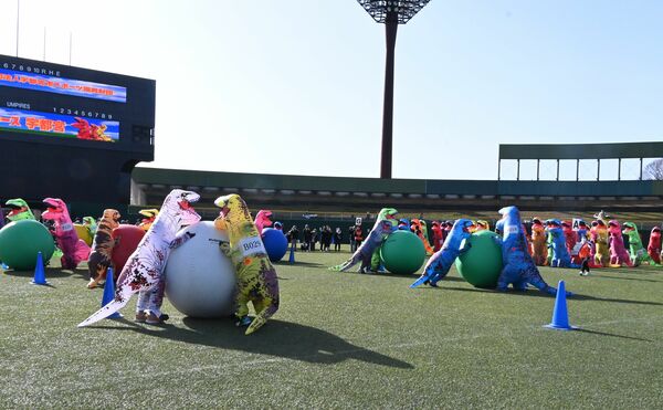 大玉転がしに挑戦する恐竜姿の参加者