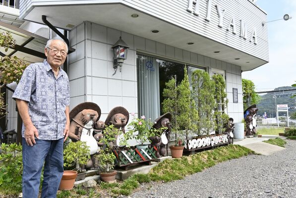 店先に並ぶタヌキ像と檜山さん