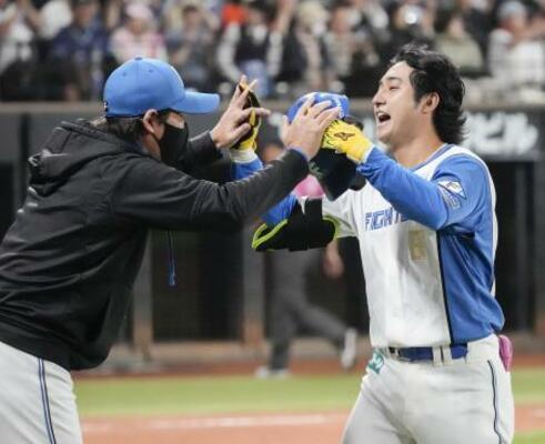 　９回、サヨナラ二塁打を放ち新庄監督（左）に迎えられる日本ハム・浅間＝エスコンフィールド