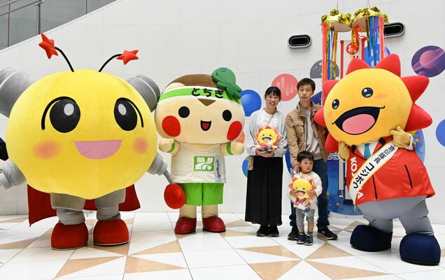 来館者５０万人目となった岡田さん一家（中央）＝２５日午前、宇都宮市西川田町