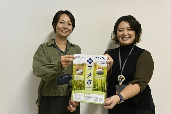 「コメ市」のチラシを持つ高山さん（左）とシンクウィッツ長谷川さん