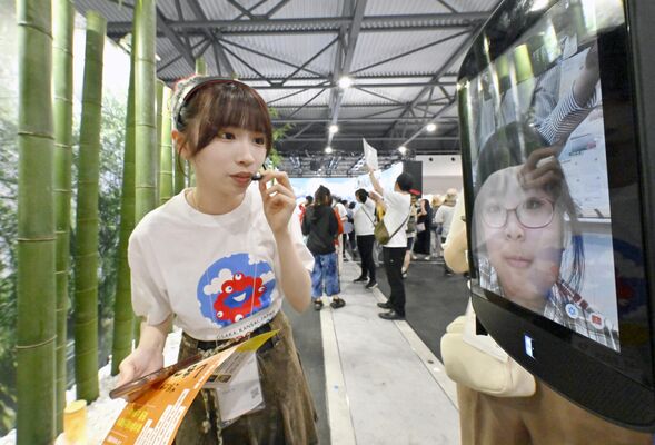 ロボットに取り付けられた画面に映る壬生小の児童（右）と会場を案内するスタッフ＝27日午後１時30分、大阪市此花区の夢洲、森田大地撮影（超広角レンズ使用）
