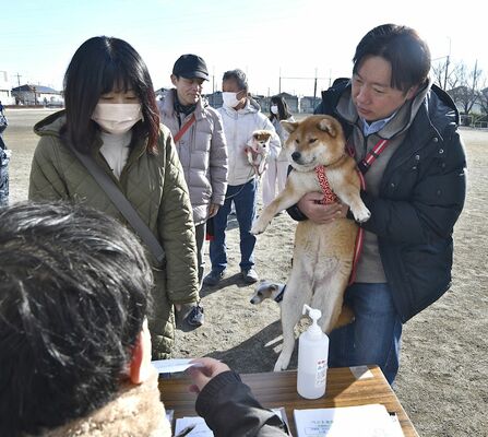 ペットの「同行避難」を想定した訓練で、受付票に記入する飼い主たち＝２月中旬、高根沢町西小