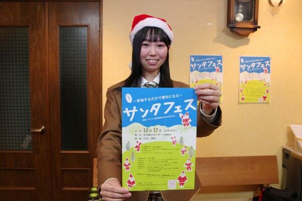 サンタフェスのチラシを持つ佐原さん