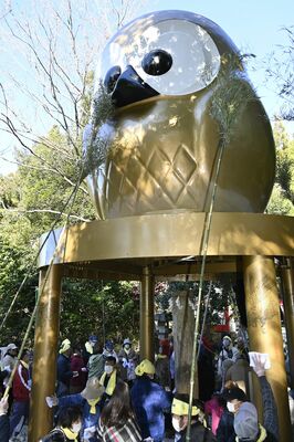 すすを払われる巨大フクロウ像