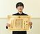 文部科学大臣賞の賞状を手にする高塩さん