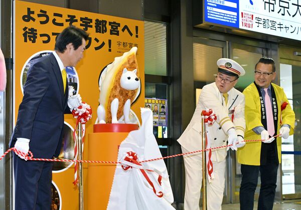 佐藤市長(左)らによって除幕された「餃子犬じゅうべえ」像=1日午前11時10分、JR宇都宮駅