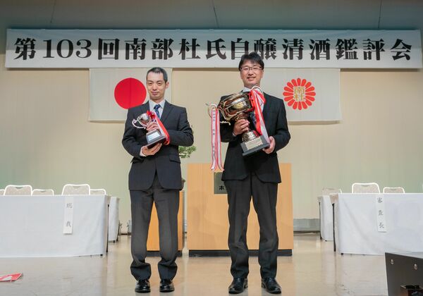 第１０３回南部杜氏自醸清酒鑑評会の表彰式で吟醸酒の部「首席」のカップを手にする渡邉社長（右）＝２０２２年５月、岩手県花巻市