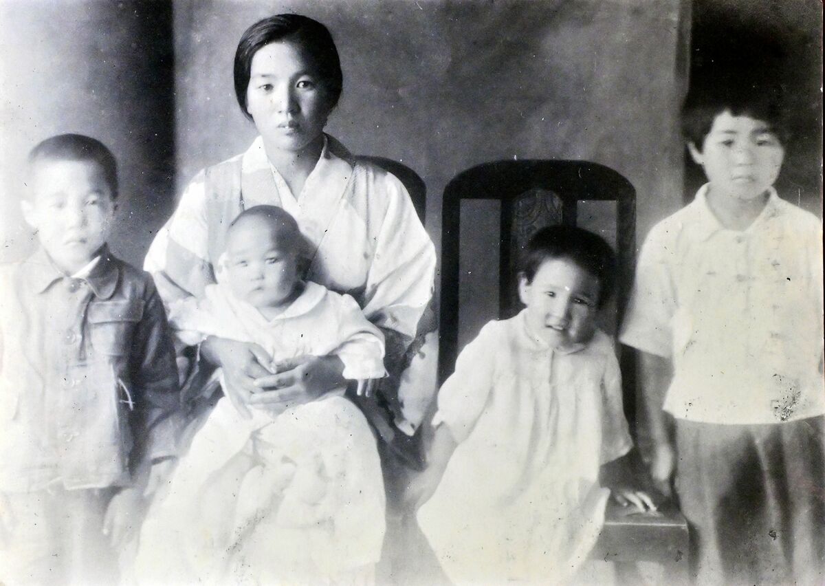 満州で撮影した家族写真。中島さん（右端）は引き揚げの際、義雄ちゃん（左から２番目の手前）を背負って逃げた（中島さん提供）