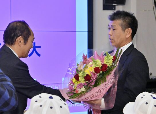 センバツ出場が決まり、花束を受け取る佐野日大の麦倉監督（右）