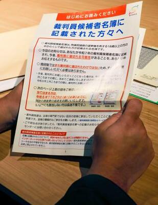 　資料を手に取材に応じる、安倍元首相銃撃事件の公判で裁判員を務めた３０代男性＝３日、奈良県内